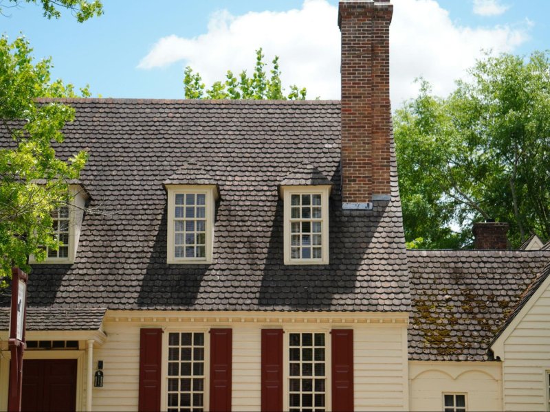 A home with visible roof stains and moss buildup in Albany, highlighting signs that professional roof washing is needed